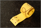 A snail made out of a curled strip of yellow paper.